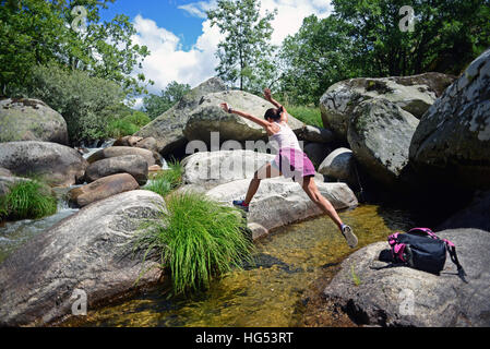 Giovane donna scendendo Los Pilones del Jerte, piscine naturali in un inferno la gola (Garganta del Infierno) in Jerte Valley, Caceres, Spagna Foto Stock