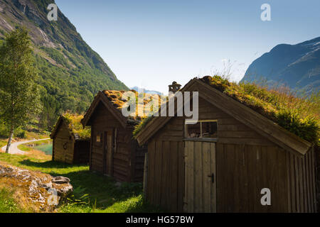 Una vista sul lago Lovatnet, una tradizionale casa norvegese si siede in primo piano e rabboccato con tetto di SOD. Foto Stock