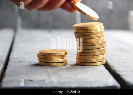 Mano che trattiene le monete d'oro Foto Stock