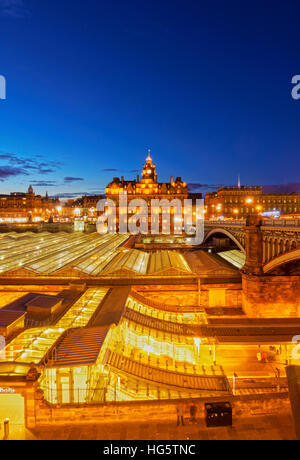 Regno Unito, Scozia, Lothian, Edimburgo, crepuscolo vista sopra la stazione ferroviaria di Waverley verso il Balmoral Hotel. Foto Stock