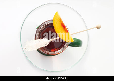 Peach tea guarnita con zucchero candito e una fresca fetta di pesche Foto Stock