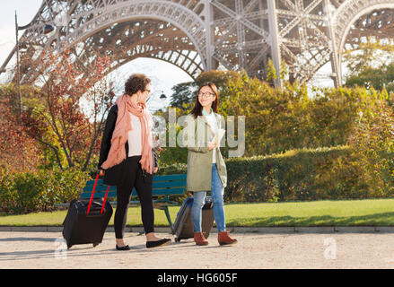 Donne tirando le valigie lungo la strada di Parigi Foto Stock