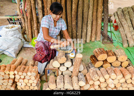 Non identificato donna birmano la preparazione di tanaka, il tradizionale faccia naturale polvere del Myanmar Foto Stock