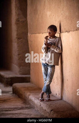 Ksar Elkhorbat, Marocco. Afro-Berber giovane ragazzo in un passaggio della casbah. Foto Stock