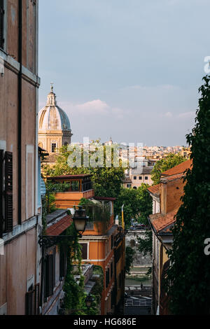 Una vista giù per una strada stretta e di una chiesa della cupola in Roma, Italia, durante l ora d'oro. Foto Stock