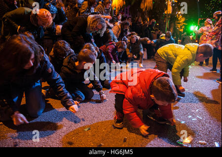 Persone alzare le loro mani come cercano di raccogliere caramelle che vengono gettati durante il 'Cabalgata de Reyes, ' o tre Saggi parade di Barcellona, Spagna, giovedì, 05 gennaio, 2017. Si tratta di un corteo che simbolizza la venuta dei Magi a Betlemme dopo la nascita di Gesù. In Spagna e in molti paesi dell America Latina Epifania è il giorno in cui i doni vengono scambiati. © Charlie Perez/Alamy Foto Stock