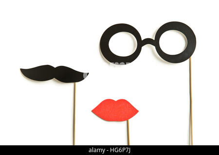 Fake labbra, bicchieri e mustaches su bastoni. Isolato su sfondo bianco. Foto Stock