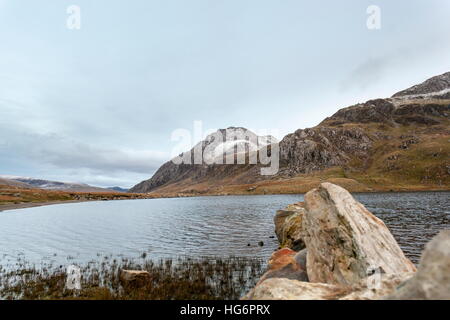 Un Snow capped Tryfan visto attraverso Llyn Idwal Foto Stock