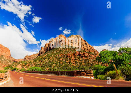 Zion National Park, Stati Uniti d'America. Eccellente con asfalto rosso strada panoramica tra le pittoresche montagne di arancione e pietra arenaria rossa. Foto Stock