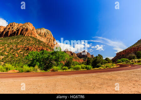 Zion National Park, Stati Uniti d'America. Eccellente con asfalto rosso strada panoramica tra le pittoresche montagne di arancione e pietra arenaria rossa. Foto Stock