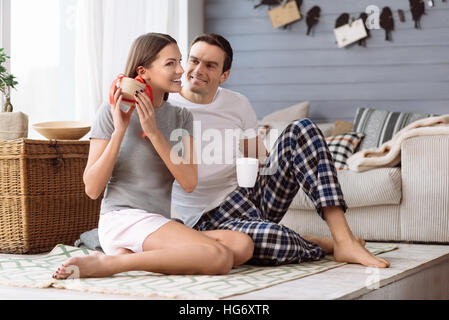 Gioiosa carino donna chiedendo che cosa è nella sua confezione regalo Foto Stock