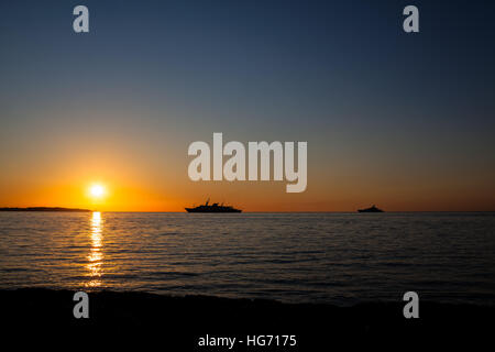 Sunrise su Cap d'Antibes vista da Palm Beach al punto Croisette di Cannes, Cote d'Azur, in Francia Foto Stock
