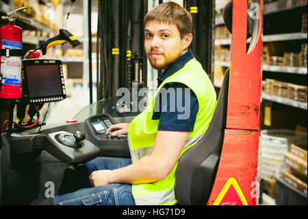 Driver uomo Reachtruck molto occupati della logistica di magazzino store Foto Stock