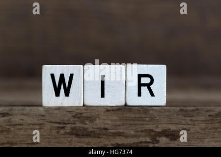 Parola tedesca abbiamo, scritto in cubi su sfondo di legno Foto Stock