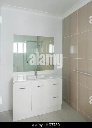 Nuovo e moderno bagno con vanity e pareti piastrellate Foto Stock