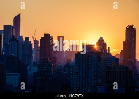 New York City, New York NYC Queens, Long Island City, vista, skyline di Manhattan, edifici, tramonto, raggi solari, arancione, giallo, silhouette, NY160723099 Foto Stock