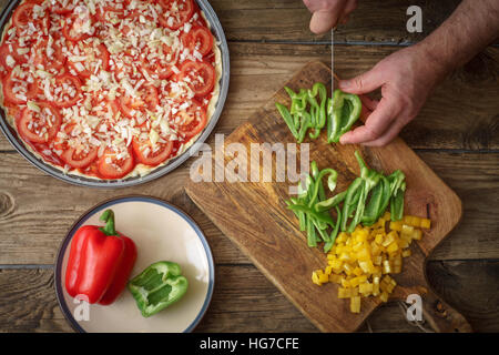 Pizza forma di cottura e fette di pepe sul tavolo orizzontale Foto Stock