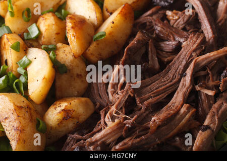 Gustosa Tirata di maiale con patate al forno macro sfondo orizzontale Foto Stock