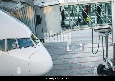 Aeromobili con corridoio di passaggio/tunnel essendo preparato per la partenza da un aeroporto internazionale - Foto Stock