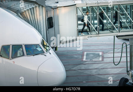 Aeromobili con corridoio di passaggio/tunnel essendo preparato per la partenza da un aeroporto internazionale Foto Stock