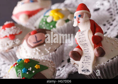 Tortini di Natale decorato con una favolosa Santa macro sul tavolo orizzontale. Foto Stock