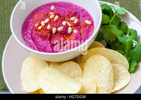 Gustosi piatti fatti in casa la barbabietola hummus con patatine e coriandolo. Cibo Vegan concetto. Foto Stock