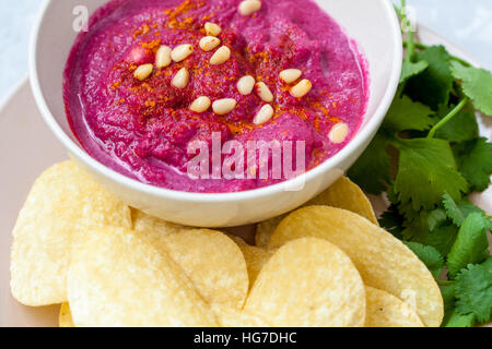 Gustosi piatti fatti in casa la barbabietola hummus con patatine e coriandolo. Cibo Vegan concetto. Foto Stock