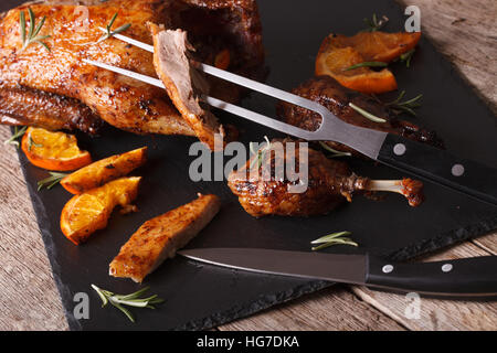 Tagliare il roast duck close up su un nero ardesia bordo. Posizione orizzontale Foto Stock