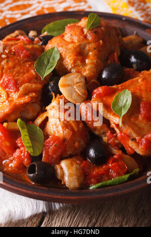 Il cibo italiano: Pollo Cacciatori con basilico su una piastra di close-up. In verticale Foto Stock