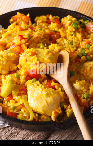 Di riso con pollo e verdure macro in una padella sul tavolo. In verticale Foto Stock