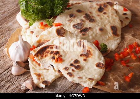 Naan pane piatto con aglio vicino sul tavolo orizzontale. Foto Stock