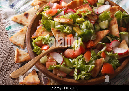 Fattoush insalata con pane pita e verdura vicino fino in una ciotola di legno orizzontale. Foto Stock