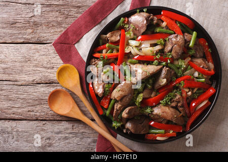 Fritti di fegato di pollo con le verdure su un piatto sul tavolo. vista orizzontale dal di sopra Foto Stock