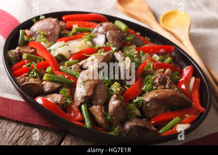 Stufati di fegato di pollo con cipolla e pepe close-up su un piatto orizzontale. Foto Stock