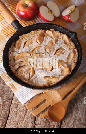 Deliziosi pancake con le mele e la cannella in una pentola su una tavola di close-up verticale. Foto Stock