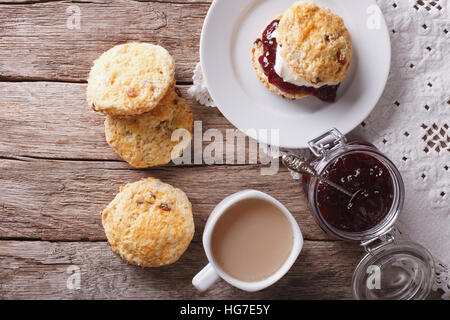 British scones con marmellata di frutta e panna montata vicino sul tavolo. Orizzontale vista superiore Foto Stock