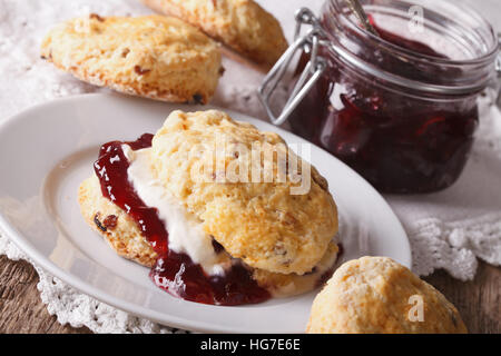 British scones con marmellata di frutta e panna montata vicino sul tavolo. Posizione orizzontale Foto Stock