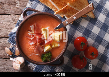 Salmorejo zuppa con prosciutto e uova in una ciotola vicino sul tavolo. vista orizzontale dal di sopra Foto Stock