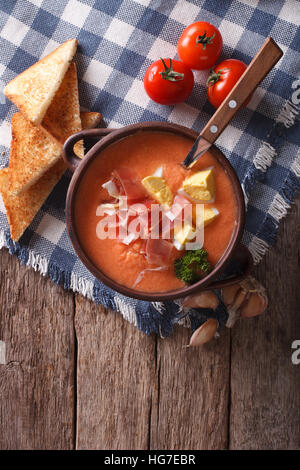 Salmorejo zuppa con prosciutto e uova in una ciotola sul tavolo. verticale vista superiore Foto Stock