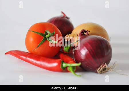 Pomodoro, carta rossa e la cipolla su uno sfondo bianco di close-up di riflessione Foto Stock