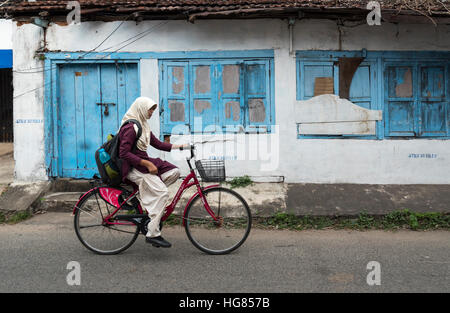 Ragazza in bicicletta nella parte anteriore della vecchia casa in città Giudeo, Mattancherry, Kochi (Cochin), Kerala, India Foto Stock