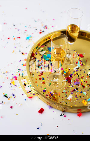 Angolo di alta vista di champagne flauti nel vassoio con i confetti sul tavolo Foto Stock