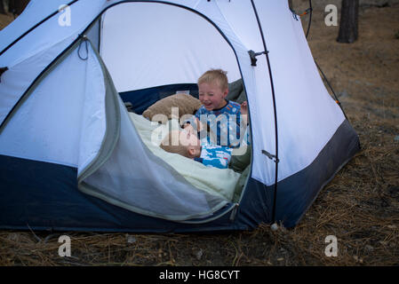 Felice fratelli rilassante in tenda sul campo Foto Stock