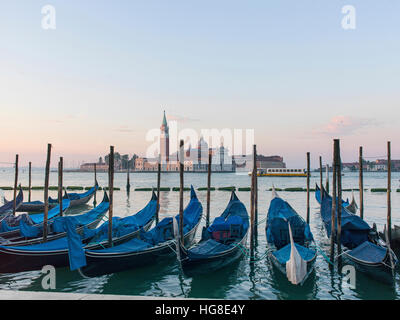 Gondole ormeggiato sul canal grande contro la piazza San Marco Foto Stock