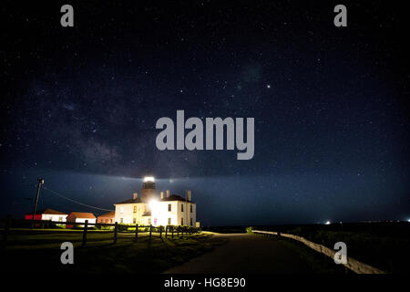 Faro illuminato sul campo contro sky Foto Stock