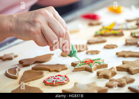 Vista parziale di donna glassa biscotti di Natale Foto Stock