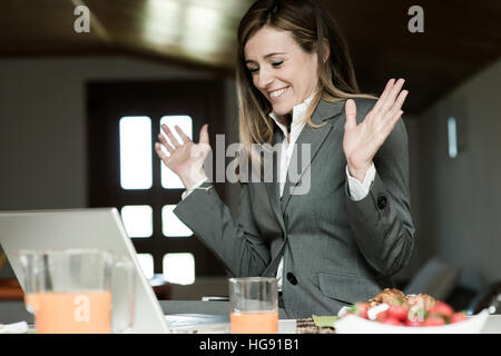 Imprenditrice eccitato a lavorare al PC durante la prima colazione Foto Stock