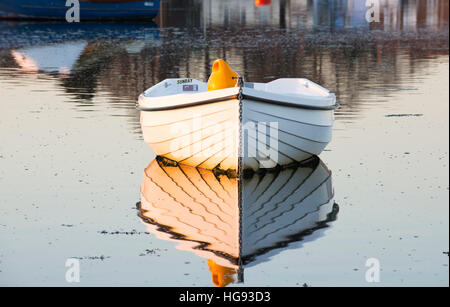 Un ormeggiate le barche a remi con la riflessione su un tranquillo pomeriggio invernale in Bosham Harbour, West Sussex, Regno Unito Foto Stock