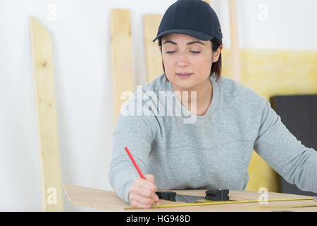 Ritratto di donna felice falegname redazione nuovo progetto in officina Foto Stock