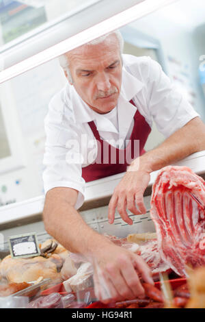 Butcher ottenere salsicce dal contatore Foto Stock